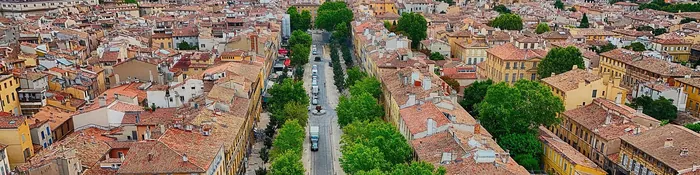 Vue aérienne du cours Mirabeau à Aix-en-Provence, son double alignement de platanes et les toits de tuiles du centre ancien