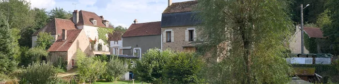 Maisons en pierre aux toits de tuiles et jardins au bord du Cousin, dans la vallée en contrebas d'Avallon