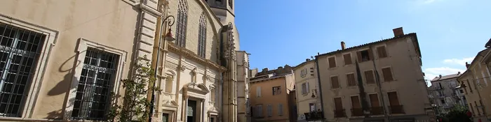 Clocher et façade de la cathédrale Saint-Siffrein de Carpentras, vus depuis une place du centre ancien avec sa fontaine