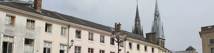 Façades claires de la place Foch à Châlons-en-Champagne, dominées par les flèches de la collégiale Notre-Dame-en-Vaux