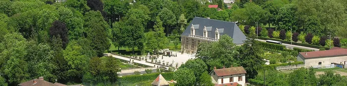 Château du Grand Jardin et ses parterres vus depuis la colline, entourés des toits et des coteaux boisés de Joinville