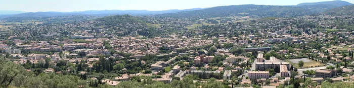 Panorama de Manosque depuis les collines : toits du centre ancien, immeubles de la plaine et villas sur les coteaux boisés